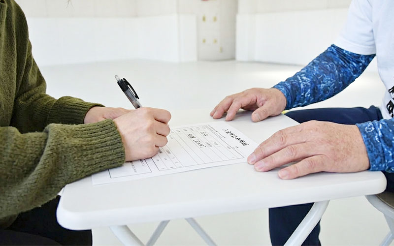入会申込書に記入する保護者