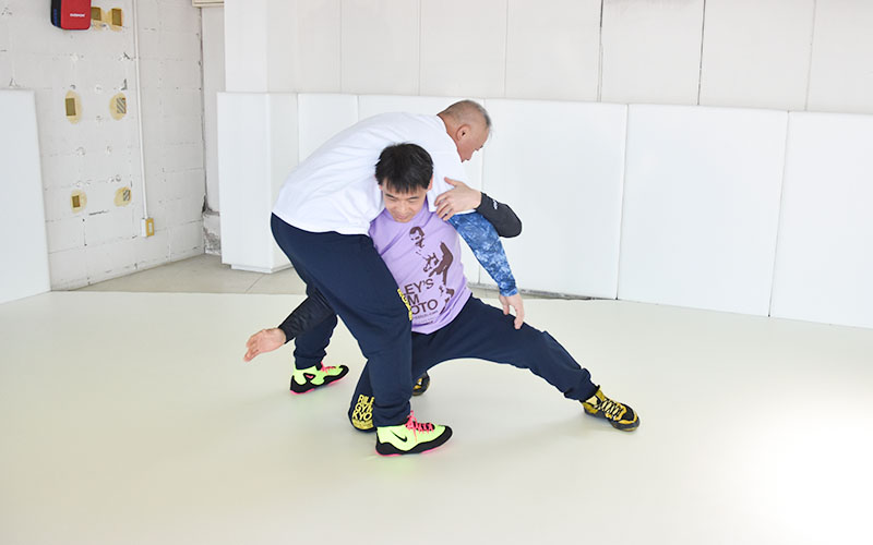 ジムでレスリングの練習をする二人の男性