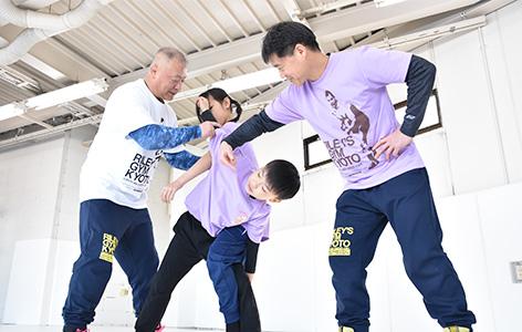 インストラクターが小学生に柔術の技を教えている